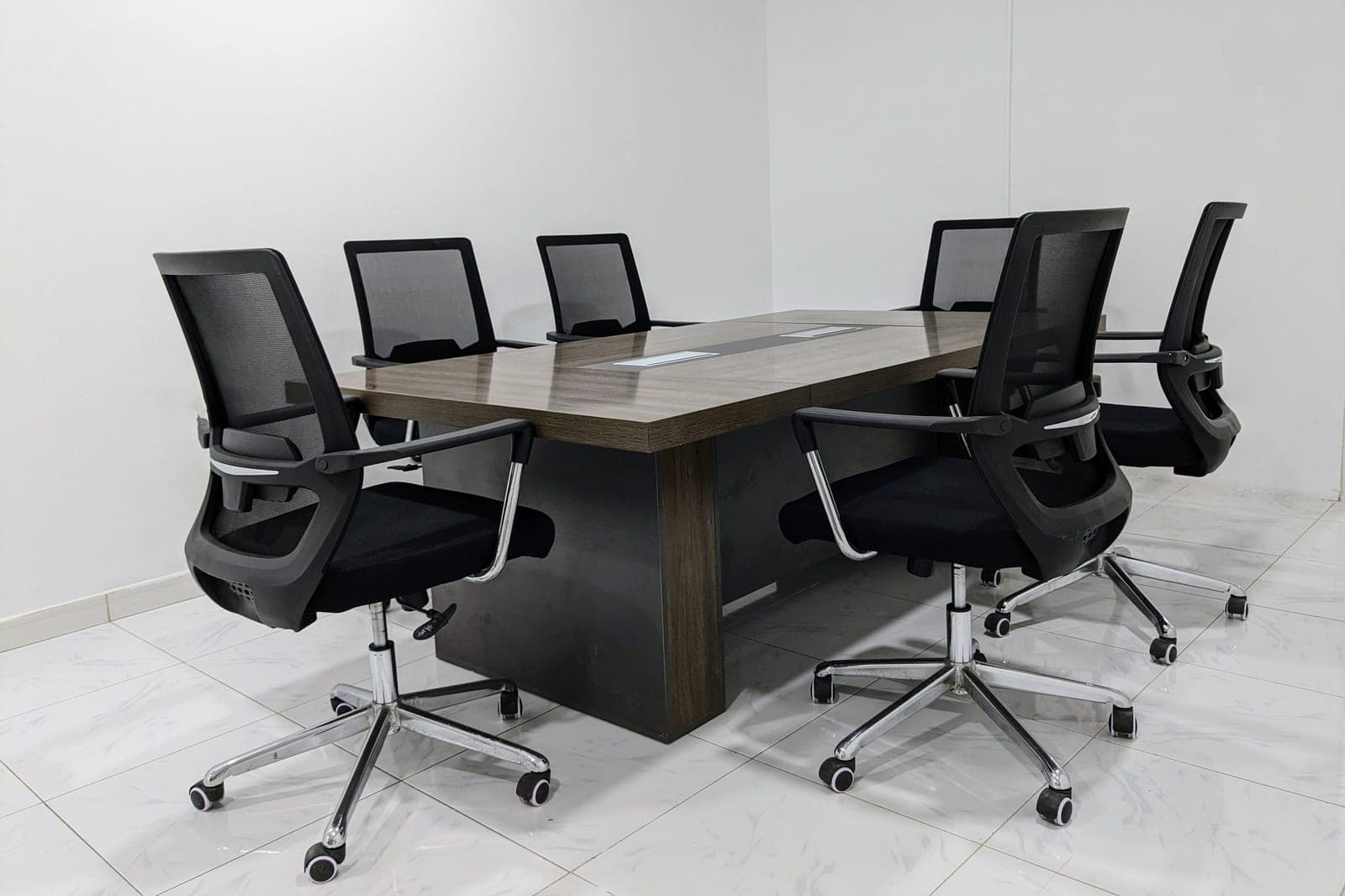 Wide-seat mesh-back task chair with a reinforced base in an office